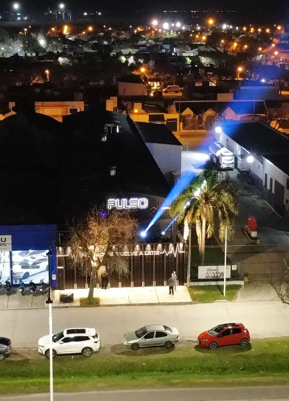 Vista aérea del frente de PULSO de noche, con el cartel encendido